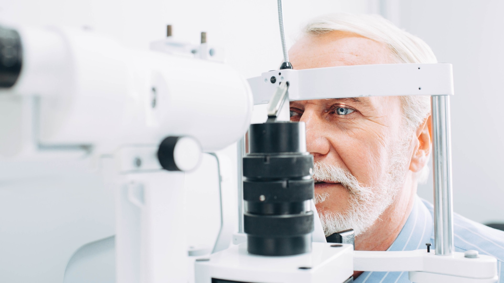 Senior patient checking vision with special eye equipment